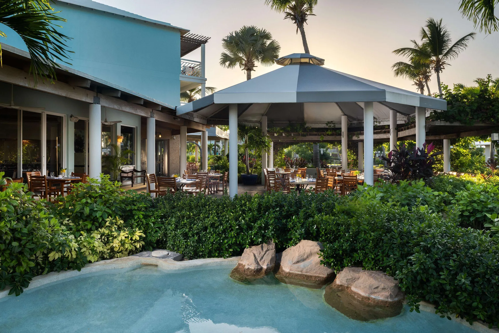 Open-air restaurant seating beside a landscaped water feature at Beaches Turks & Caicos.