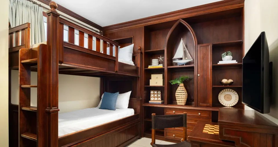 Kids room with wooden bunk bed and TV in a family suite at Beaches Turks & Caicos.