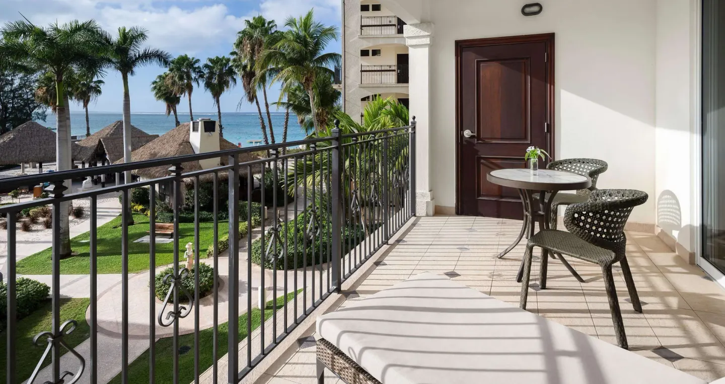 Ocean-view balcony of a family suite at Beaches Turks & Caicos with seating, palms and water beyond.