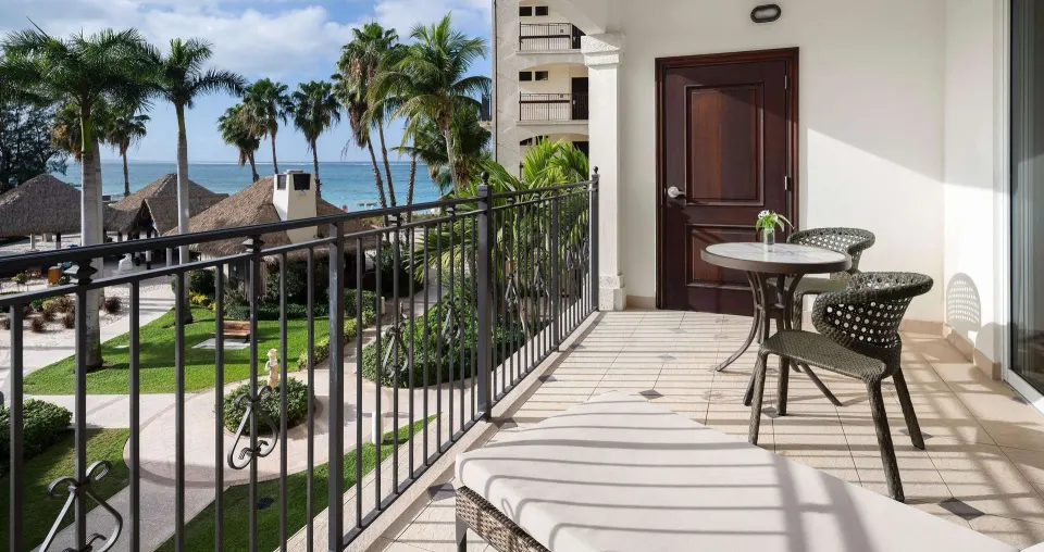 Ocean-view balcony of a family suite at Beaches Turks & Caicos with seating, palms and water beyond.