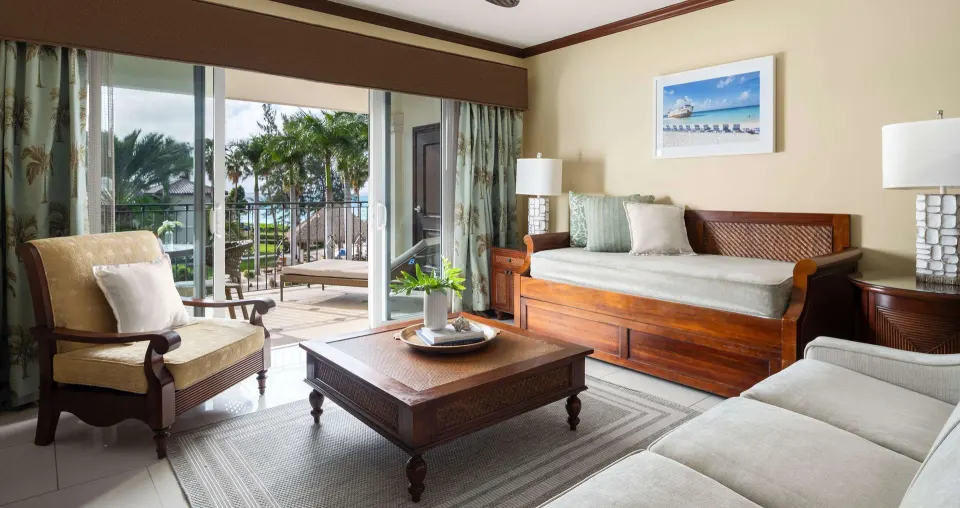 Living area of an ocean-view family suite at Beaches Turks & Caicos with daybed and balcony doors.