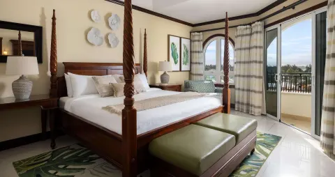Ocean-view family suite bedroom with four-poster king bed at Beaches Turks & Caicos.