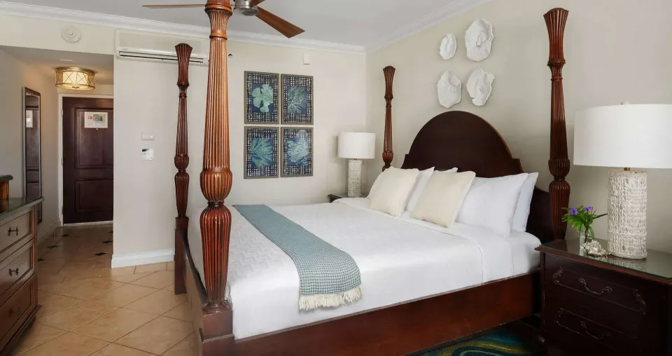 Luxury Room at Beaches Turks & Caicos with a four-poster king bed, wall art, lamps, and entry area.