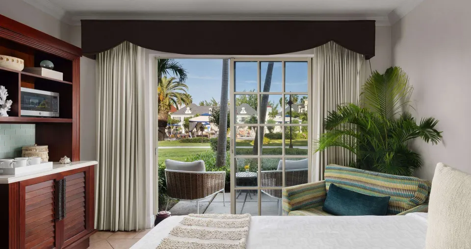 Bedside view of a Luxury Room with patio seating at Beaches Turks & Caicos.