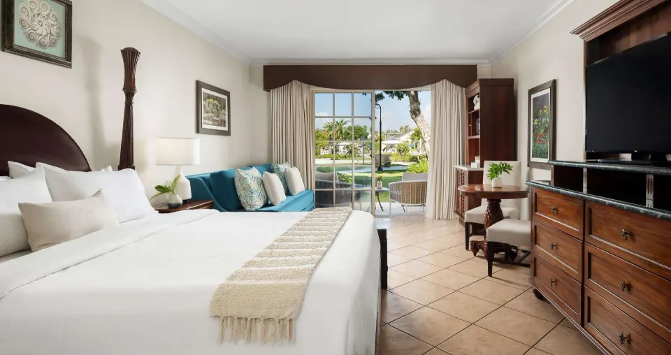 Luxury Room with king bed, dresser, sofa, and garden patio at Beaches Turks & Caicos.