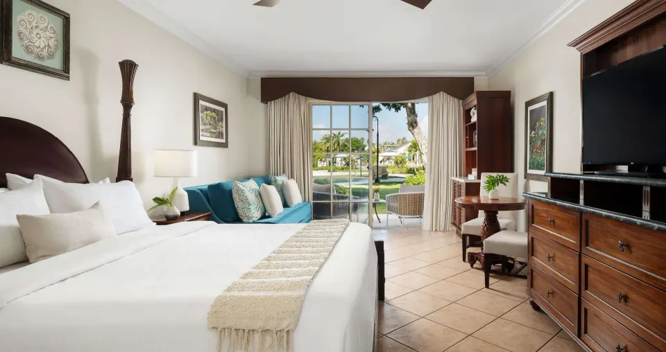 King bed, sofa, and garden walkout in a Luxury Room at Beaches Turks & Caicos.