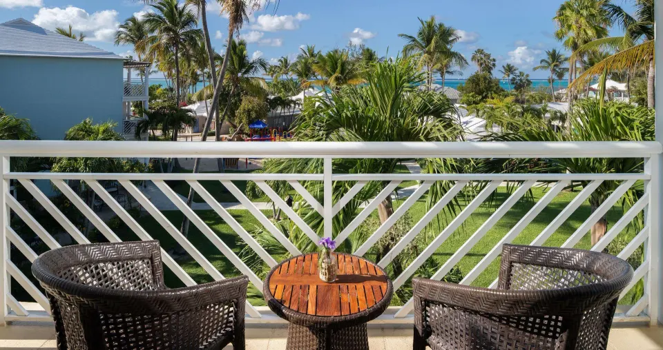 Furnished balcony with garden, palms, and ocean glimpses at Beaches Turks & Caicos.