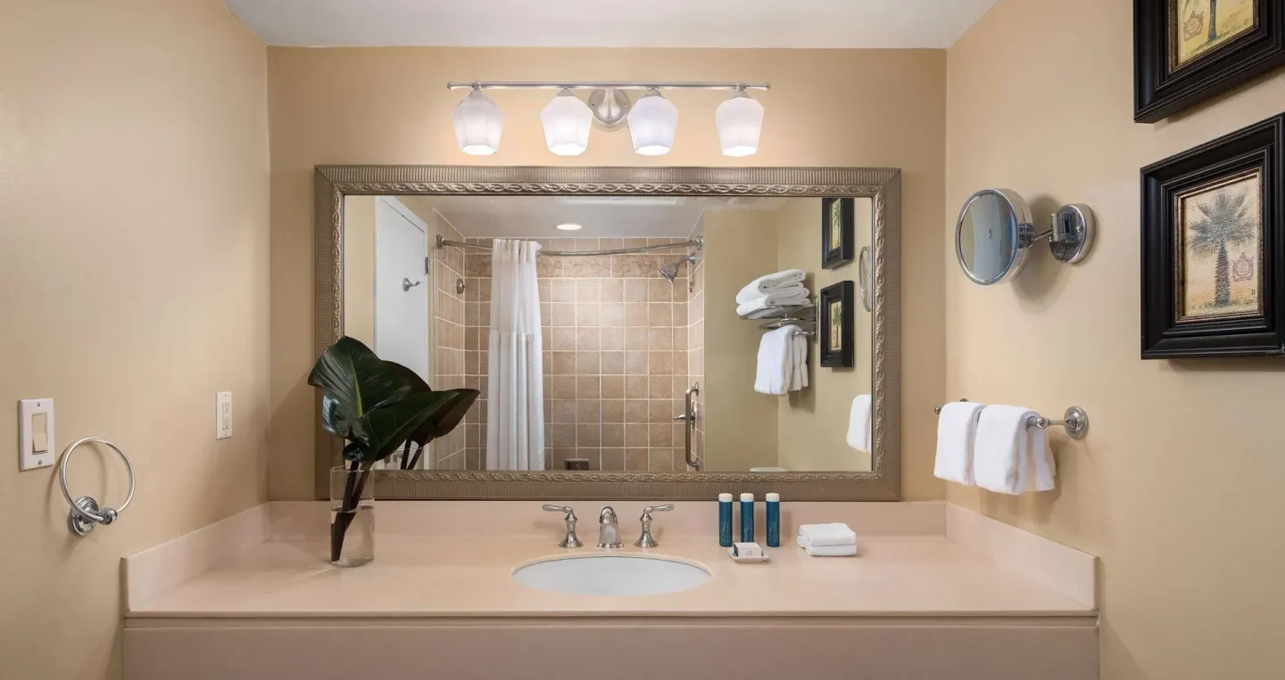 Guest room bathroom vanity and shower at Beaches Turks & Caicos with mirror and towels.