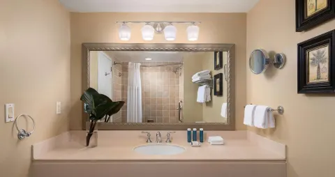 Guest room bathroom vanity and shower at Beaches Turks & Caicos with mirror and towels.