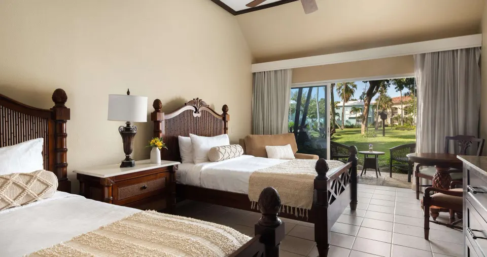 Two-bed garden-view guest room at Beaches Turks & Caicos with patio doors and seating.