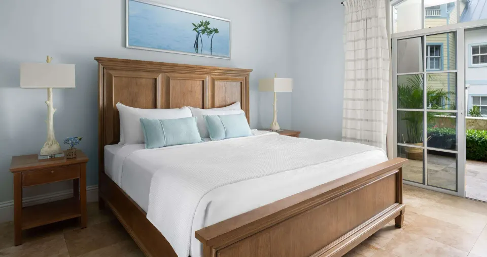 King bed in a Luxury Suite at Beaches Turks & Caicos with pale blue accents and patio doors.