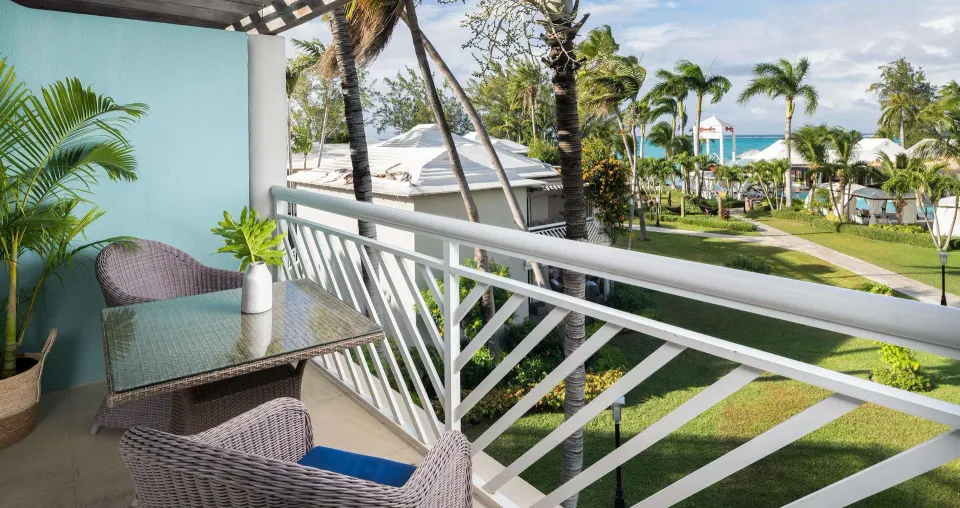 Balcony seating overlooks palms and the sea at Beaches Turks & Caicos.