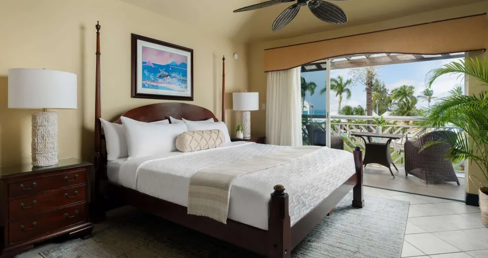 King bed beside sliding balcony doors in a suite at Beaches Turks & Caicos.