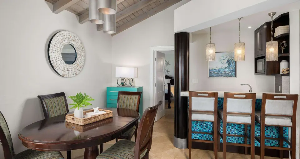 Dining and bar area in a luxury suite at Beaches Turks & Caicos with table, stools, and pendant lights.