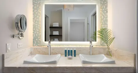 Double vanity in a luxury suite bathroom at Beaches Turks & Caicos with lit mirror and amenities.