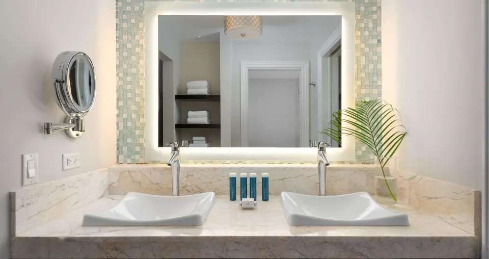 Double vanity in a luxury suite bathroom at Beaches Turks & Caicos with lit mirror and amenities.