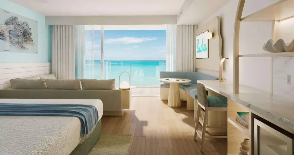 King bed, sofa, dining nook, and ocean view in a suite at Beaches Turks & Caicos.