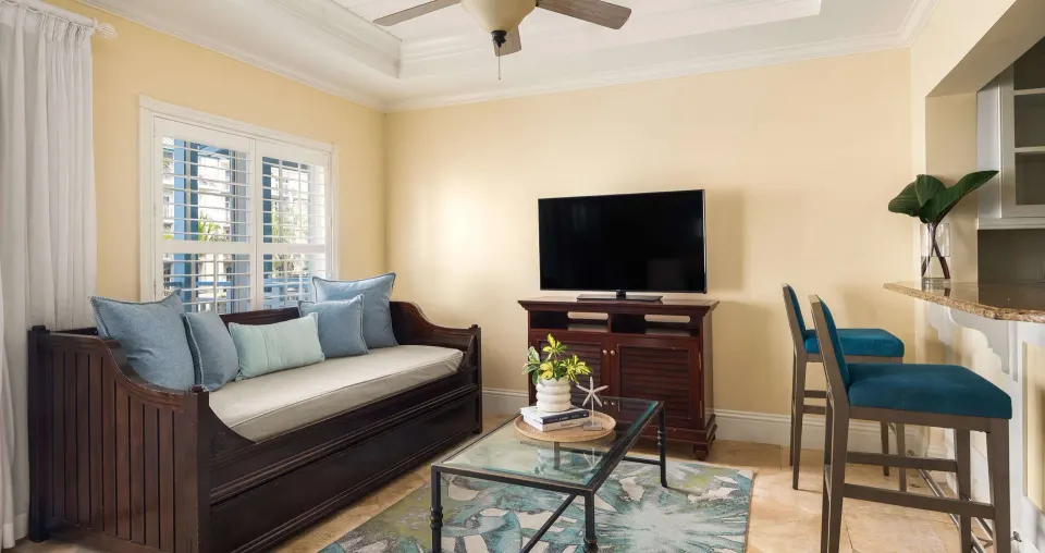 Living area with daybed, TV and breakfast bar at Beaches Turks & Caicos.