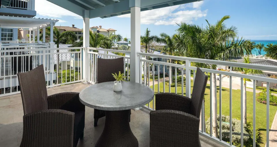 Covered ocean-view suite balcony with dining table at Beaches Turks & Caicos.