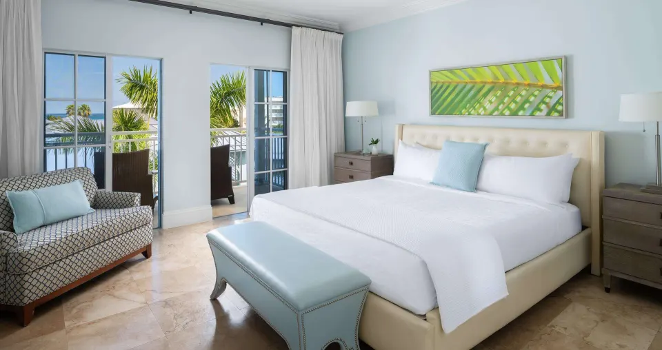 Ocean-view suite bedroom with king bed and balcony seating at Beaches Turks & Caicos.