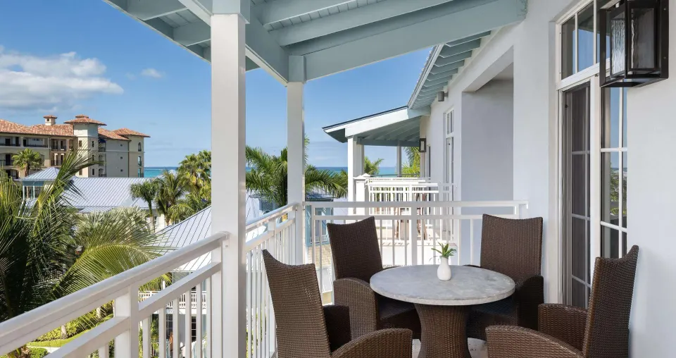 Ocean-view suite wraparound balcony with table and chairs at Beaches Turks & Caicos.