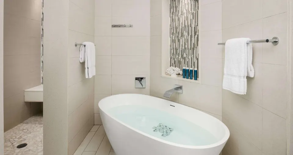 Villa bathroom with soaking tub, towels, and walk-in shower at Beaches Turks & Caicos.