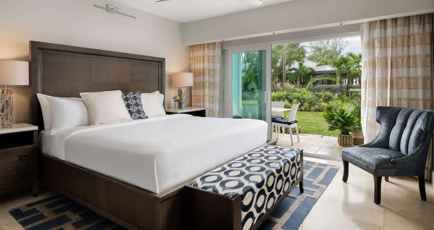 Garden-view villa bedroom with king bed and patio at Beaches Turks & Caicos.