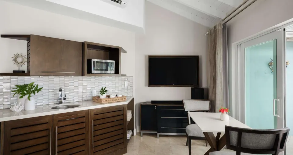 Villa kitchenette and dining area with TV at Beaches Turks & Caicos.