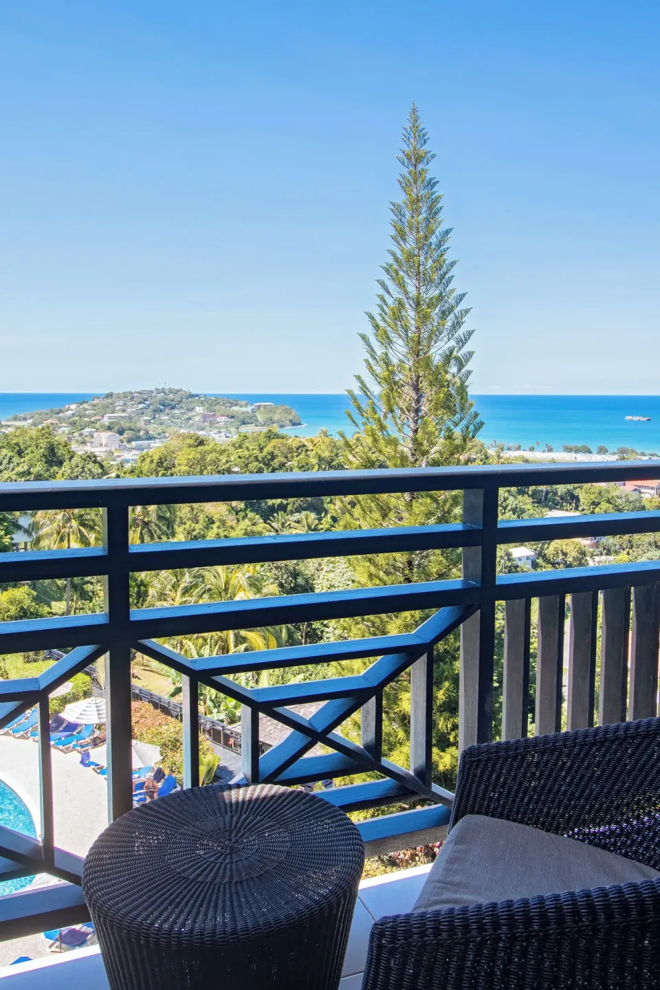 Balcony seating with sea and hillside views at Bel Jou Hotel.