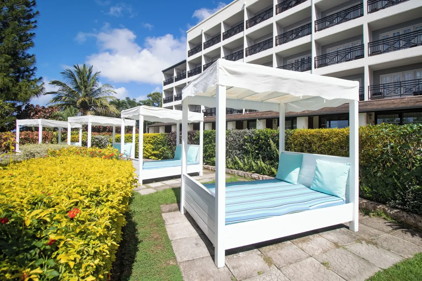 White cabana daybeds in the landscaped gardens at Bel Jou Hotel.