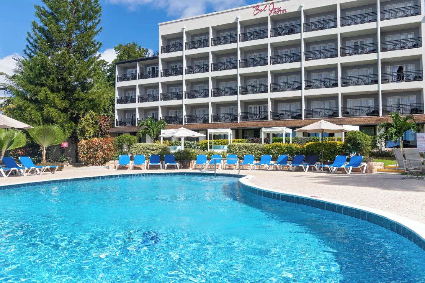 Main pool and multi-story hotel building with balconies at Bel Jou Hotel.