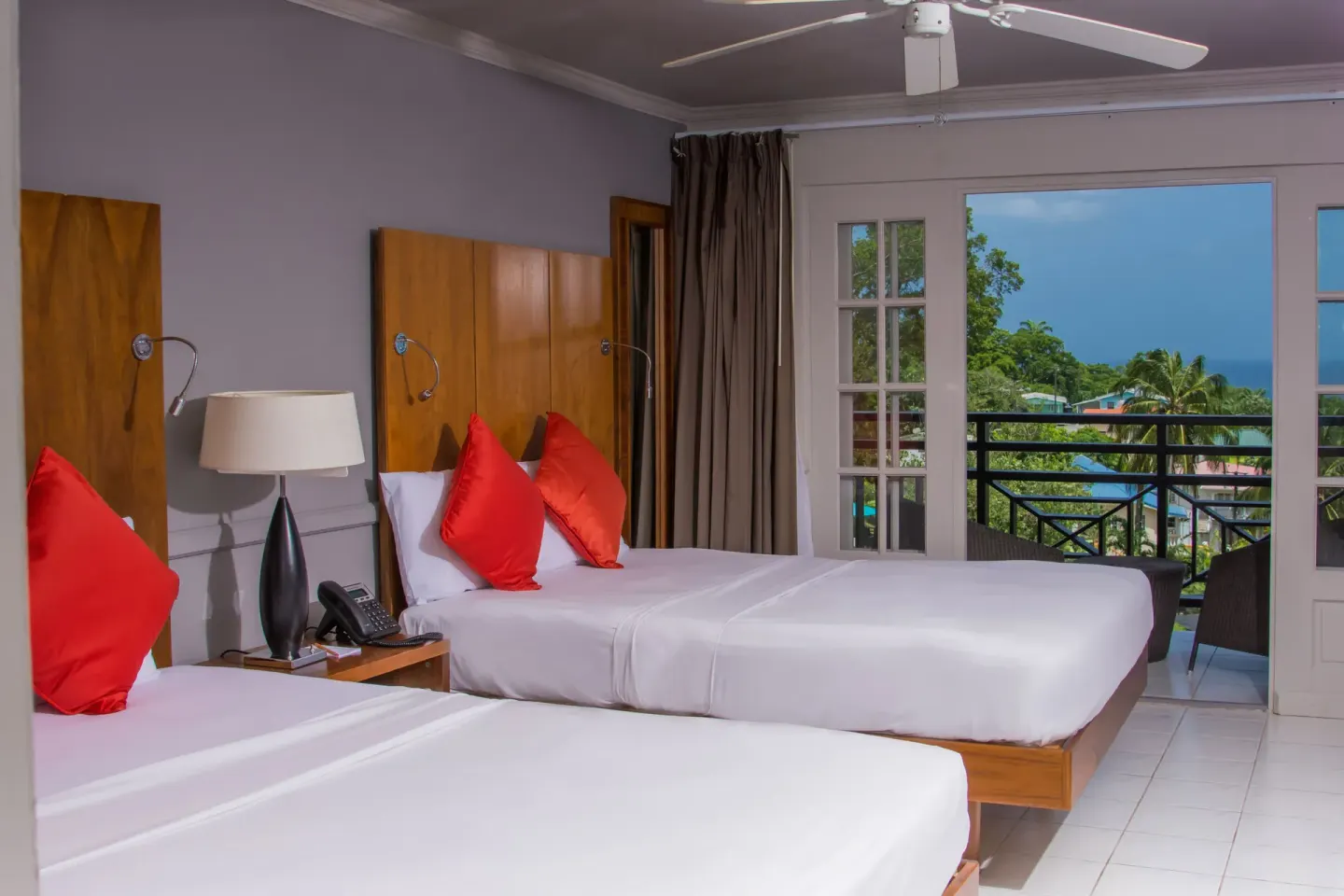 Twin-bed guest room with balcony and sea view at Bel Jou Hotel.