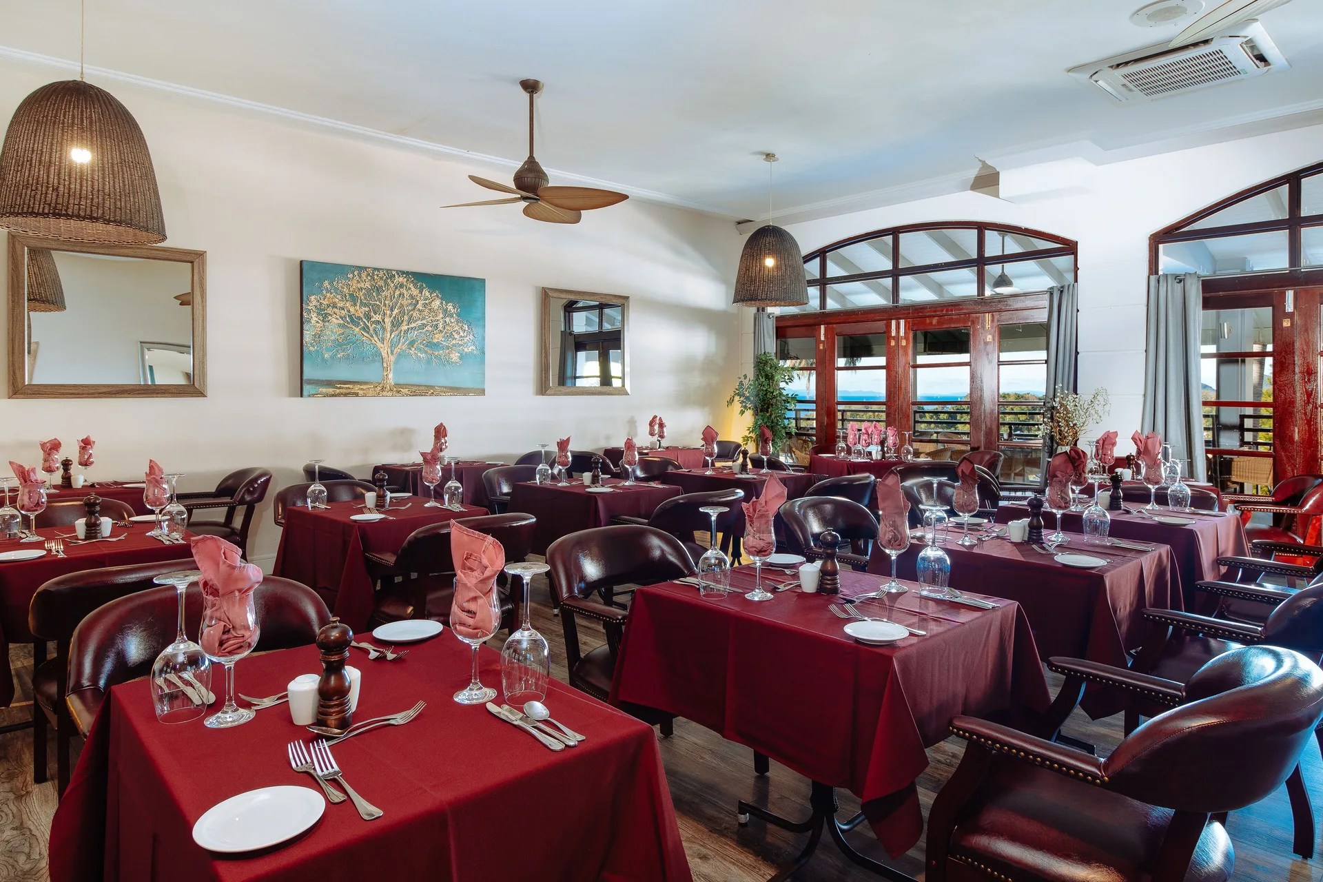 Indoor dining room with red tablecloths and set tables at Bel Jou Hotel.