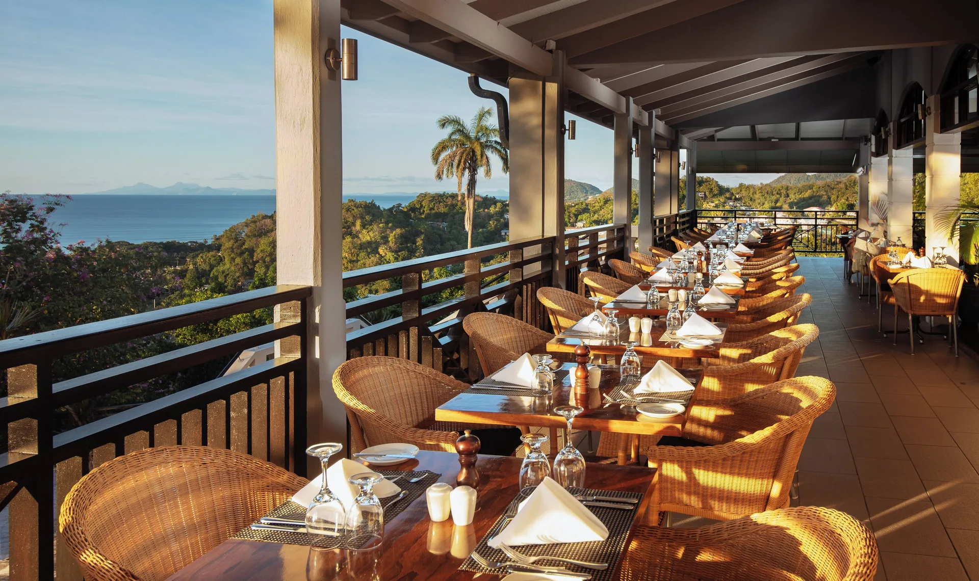 Open-air restaurant terrace with set tables and sea views at Bel Jou Hotel.
