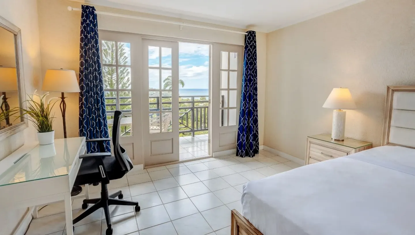 Garden View guest room with bed, desk, and balcony doors at Bel Jou Hotel.
