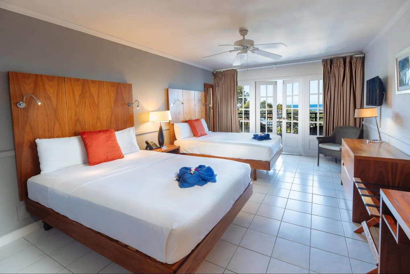 Ocean View room with two beds, balcony doors, and sea view at Bel Jou Hotel.