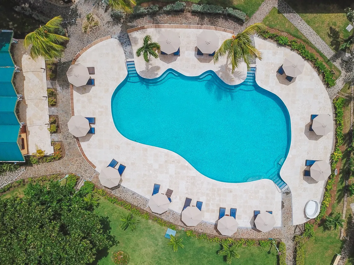 Aerial view of the freeform pool, loungers and garden paths at Bequia Beach Hotel.