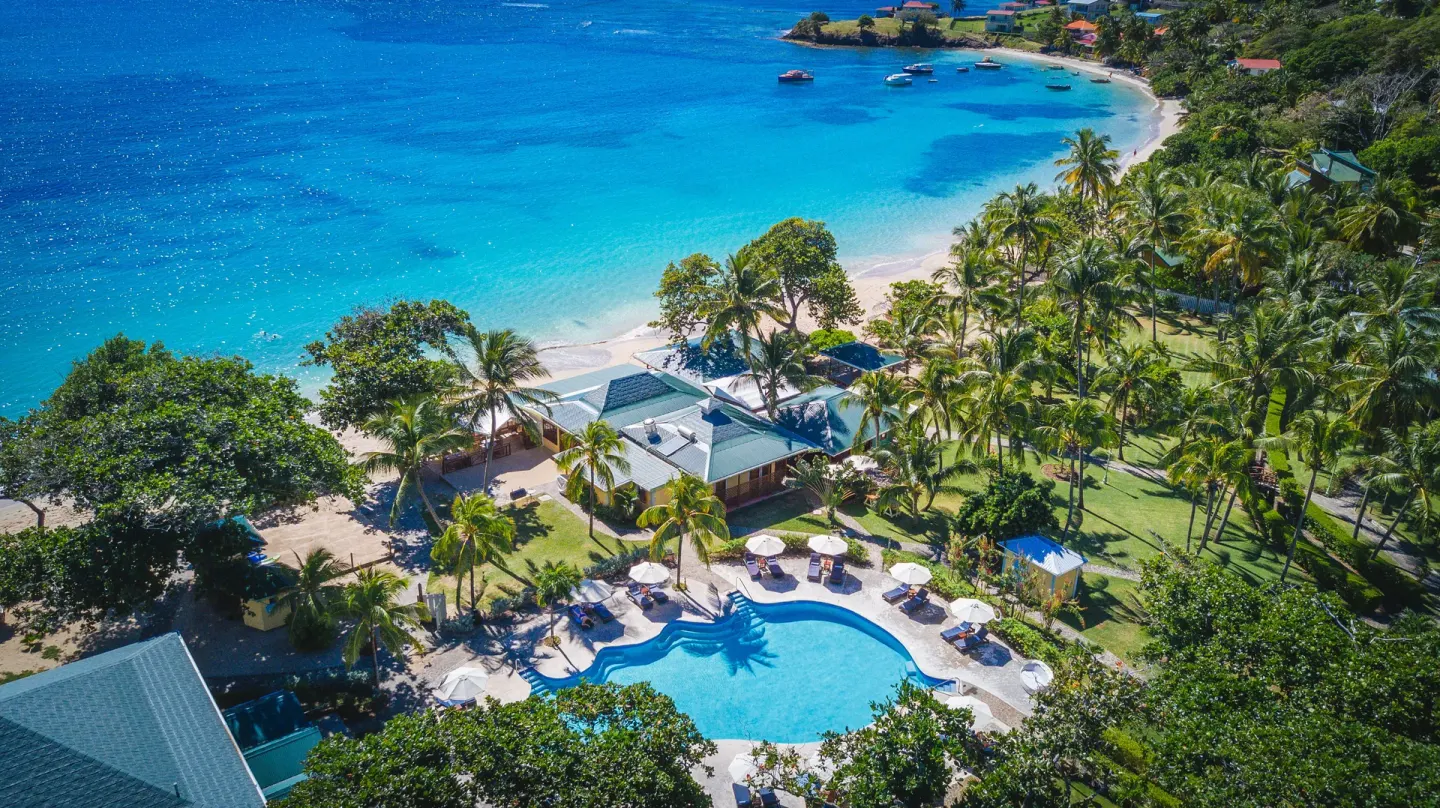 Aerial view of the resort pool, palms, beach and turquoise sea at Bequia Beach Hotel.