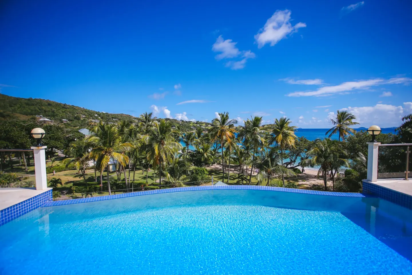 Infinity pool overlooking palms, beach and blue sea at Bequia Beach Hotel.
