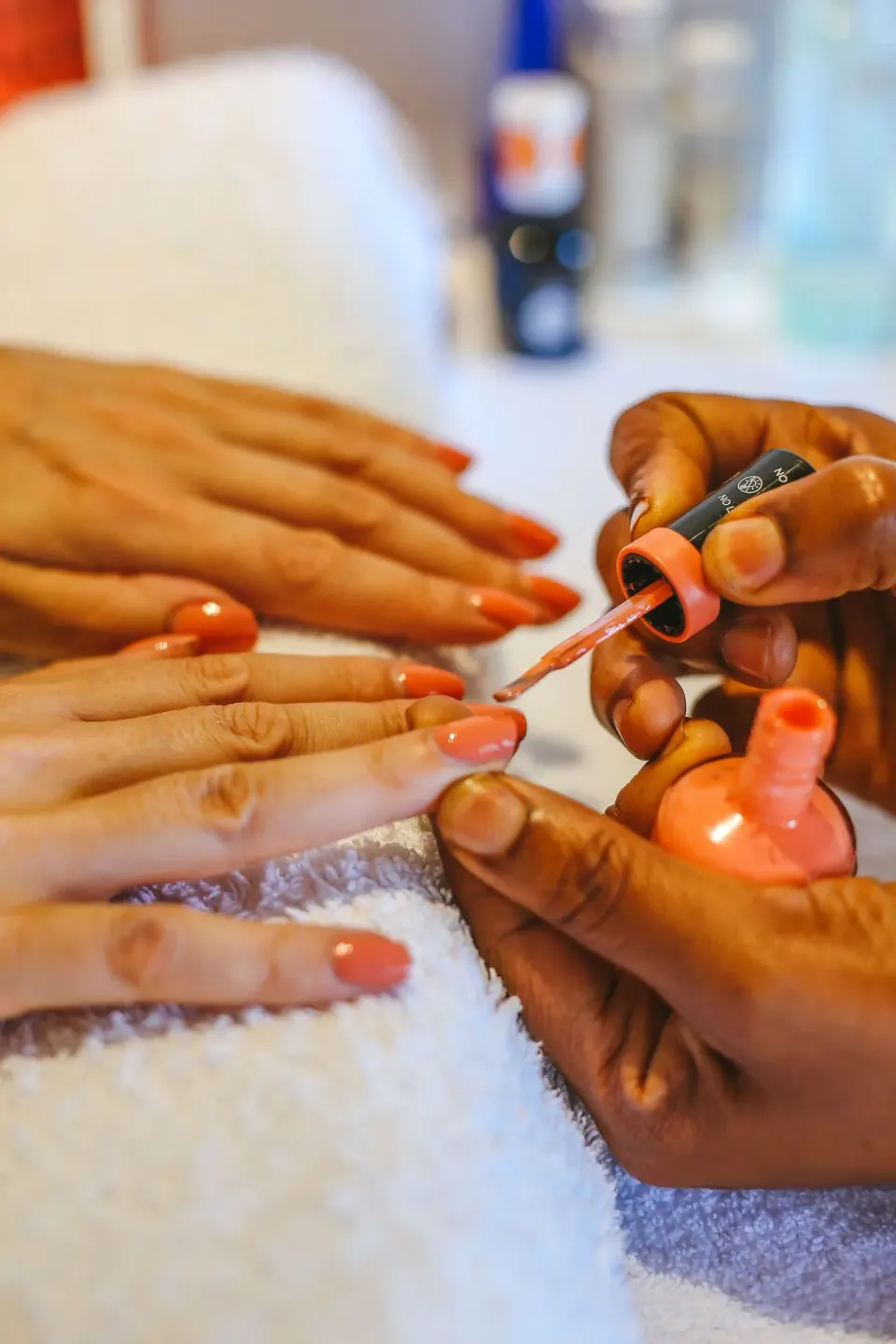 Close-up of coral nail polish being applied during a manicure at Bequia Beach Hotel.