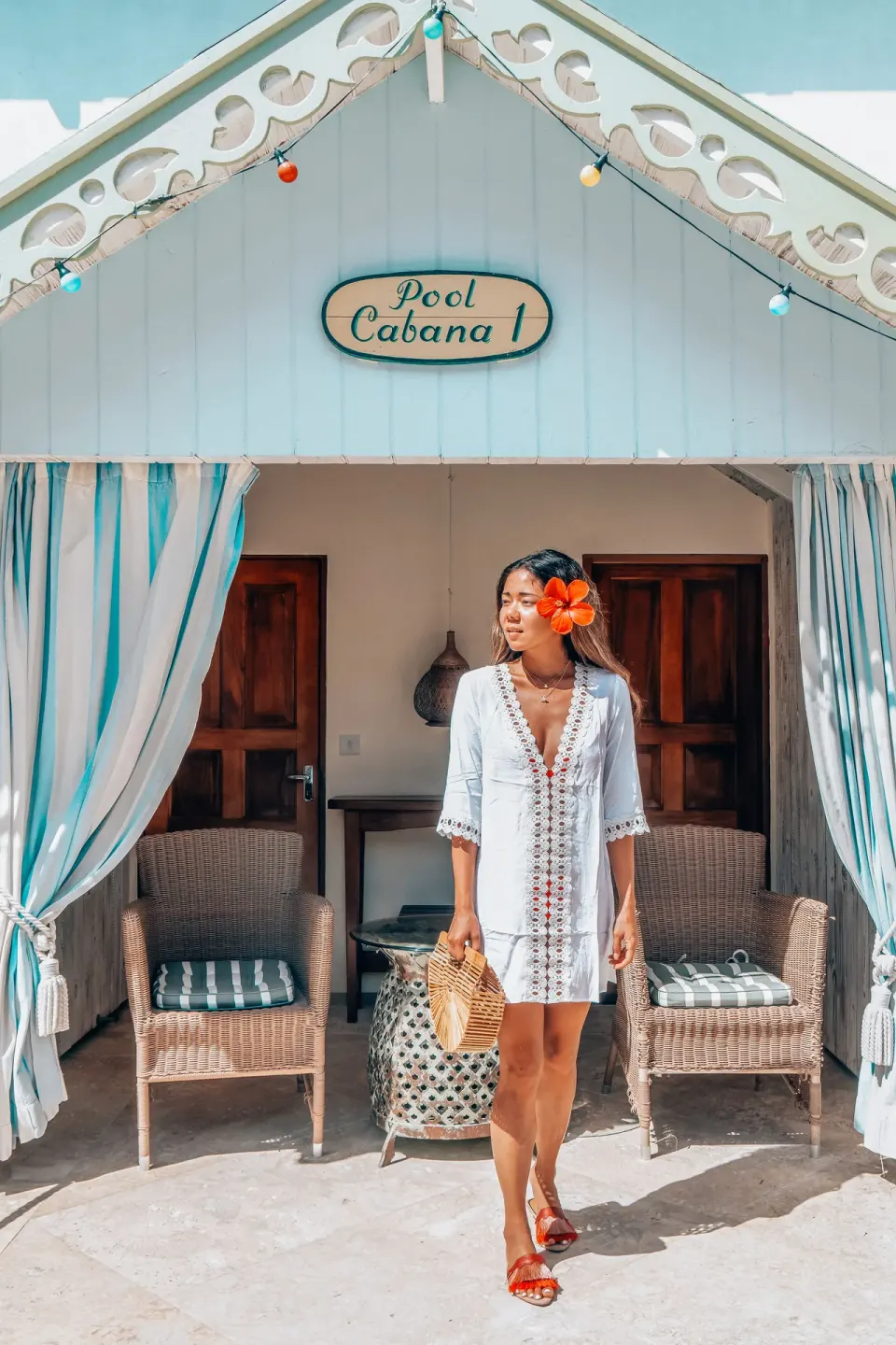 Guest stands at Pool Cabana 1 with wicker chairs at Bequia Beach Hotel.
