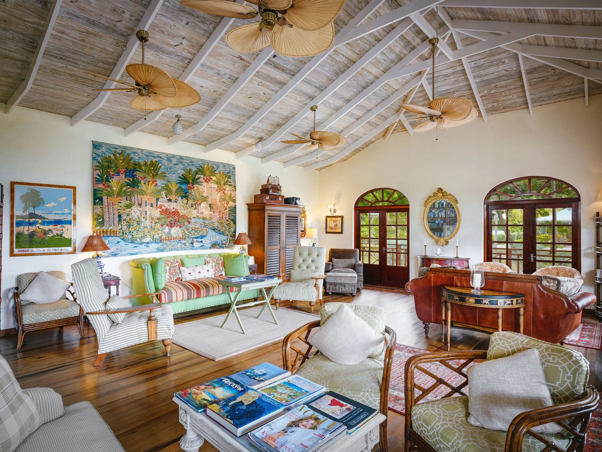 Lounge with tropical mural, sofas and vaulted ceiling at Bequia Beach Hotel.
