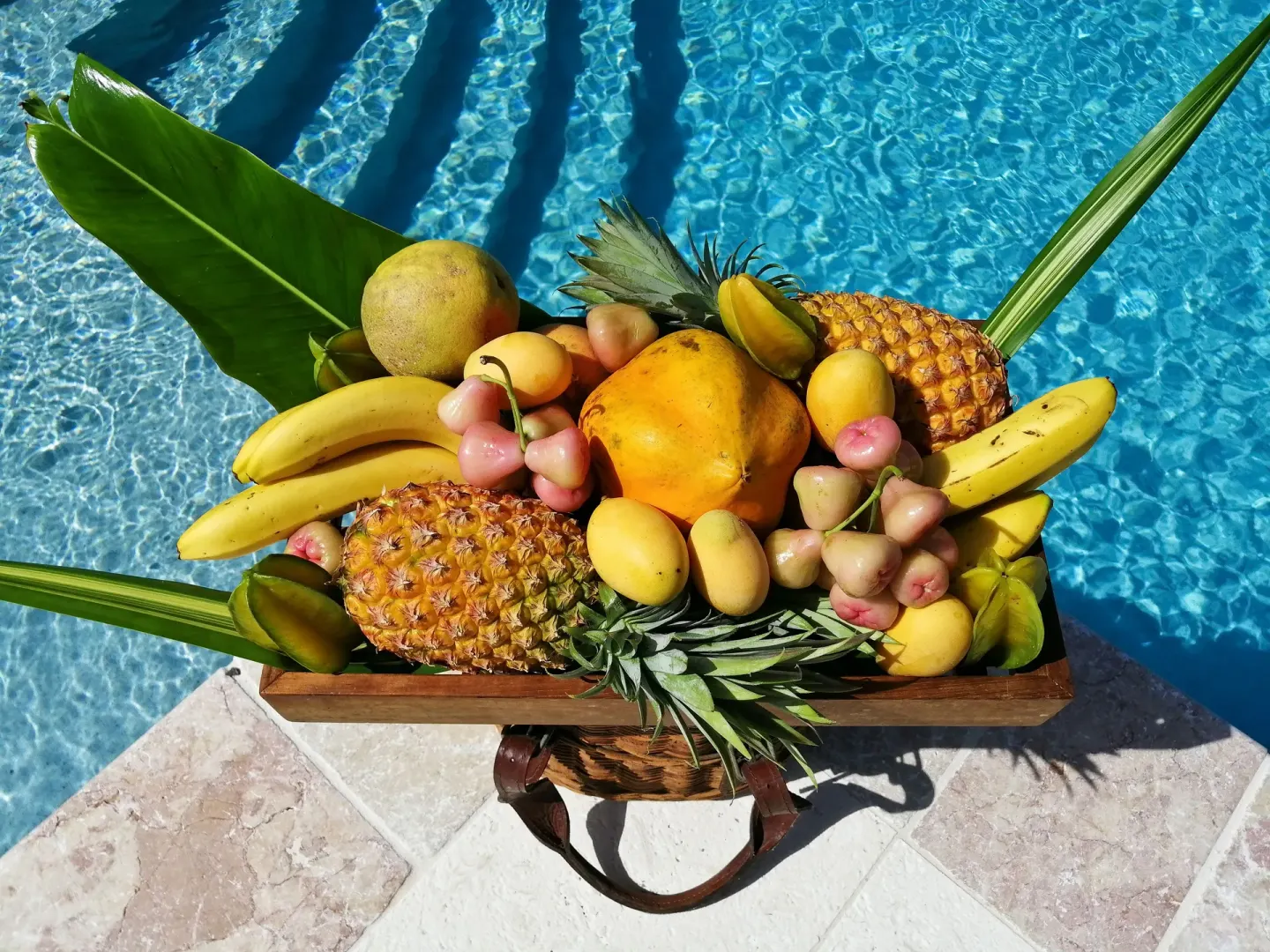 Tropical fruit basket beside a blue swimming pool at Bequia Beach Hotel.
