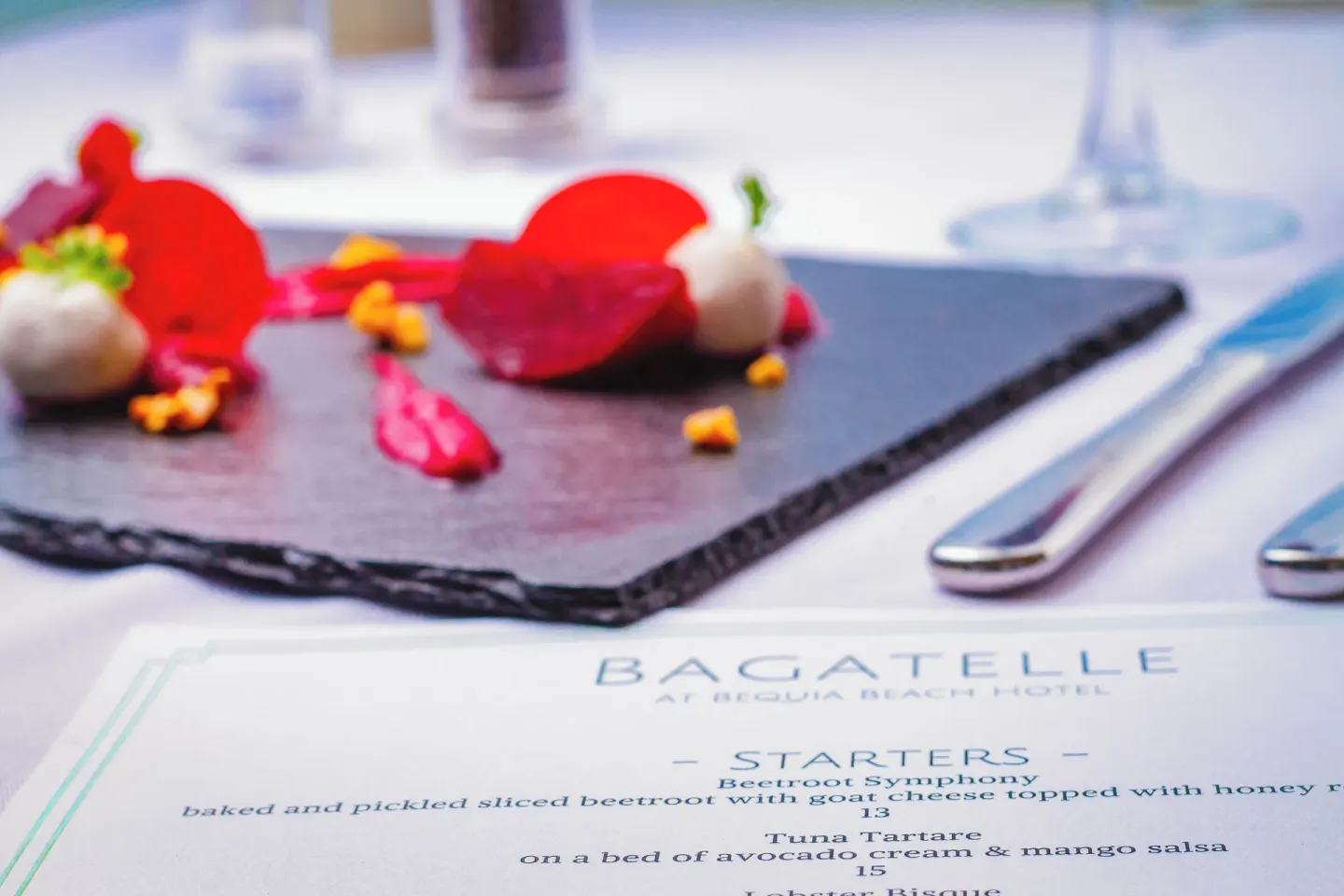 Bagatelle menu and plated beetroot starter on a dining table at Bequia Beach Hotel.