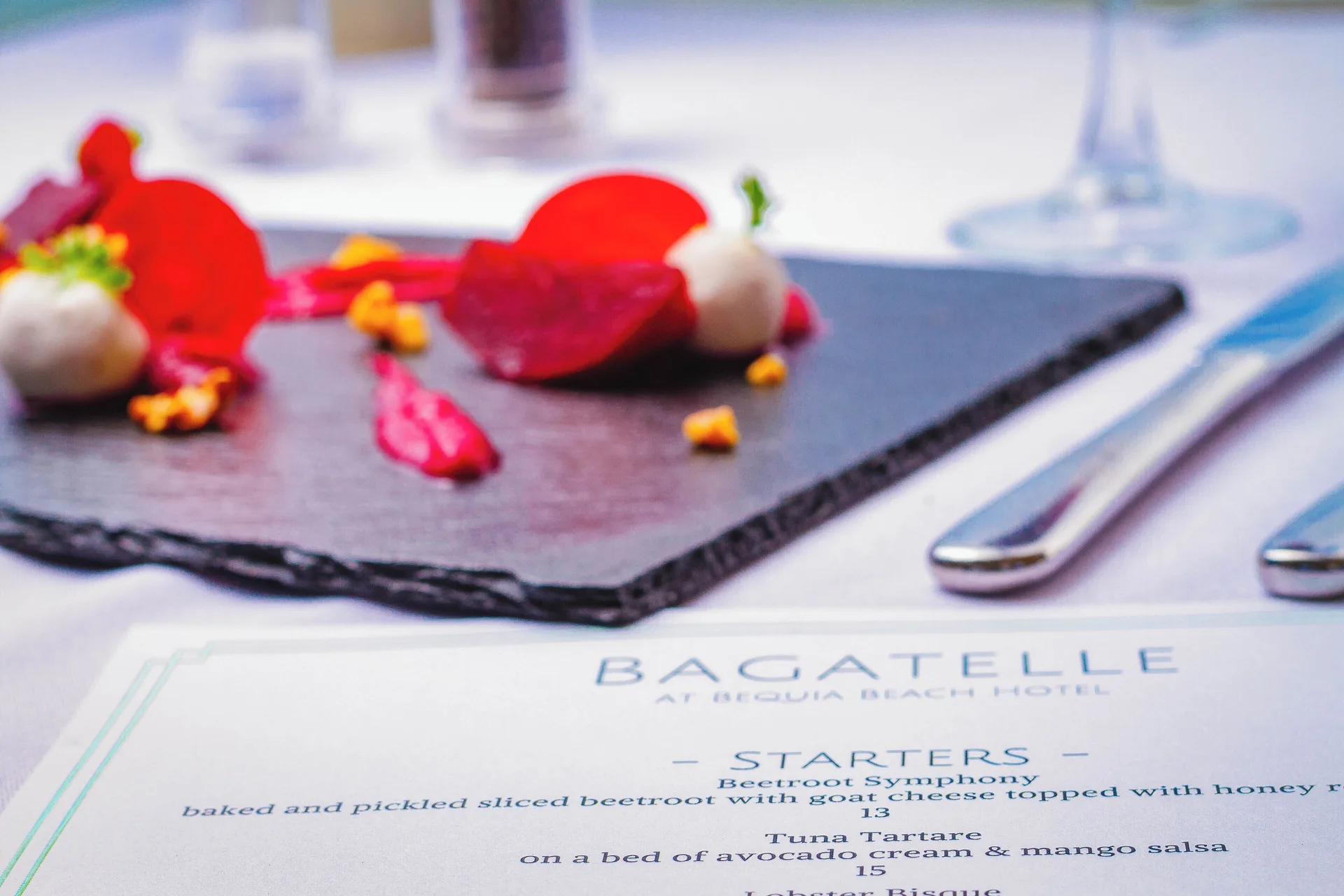 Bagatelle menu and plated beetroot starter on a dining table at Bequia Beach Hotel.