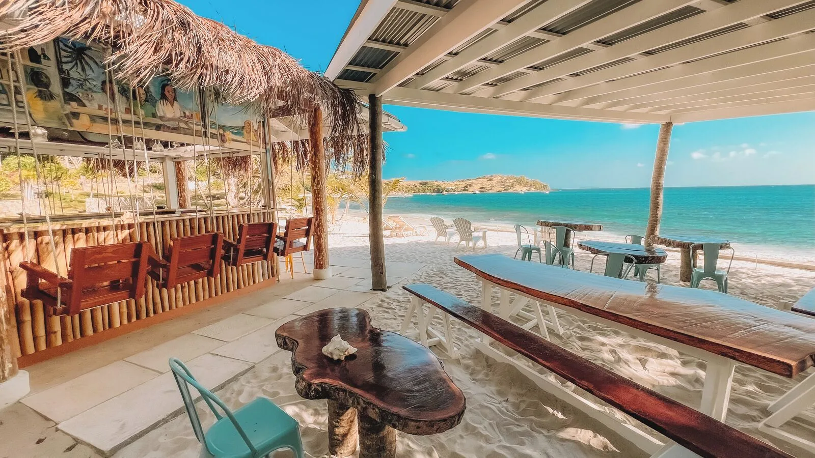Beachfront bar seating beside the sand and sea at Bequia Beach Hotel.