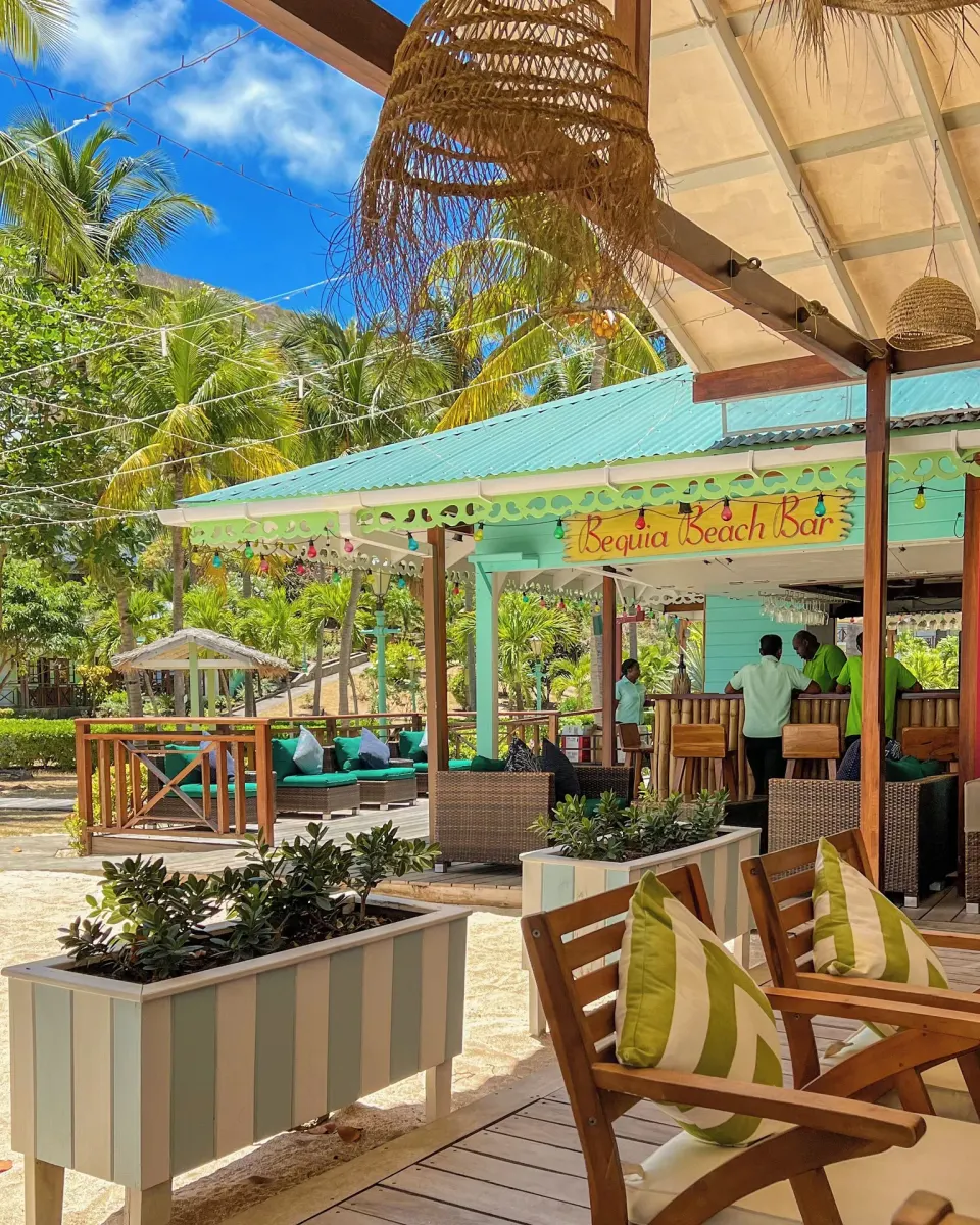 Bequia Beach Hotel with deck seating and palms at Bequia Beach Hotel.
