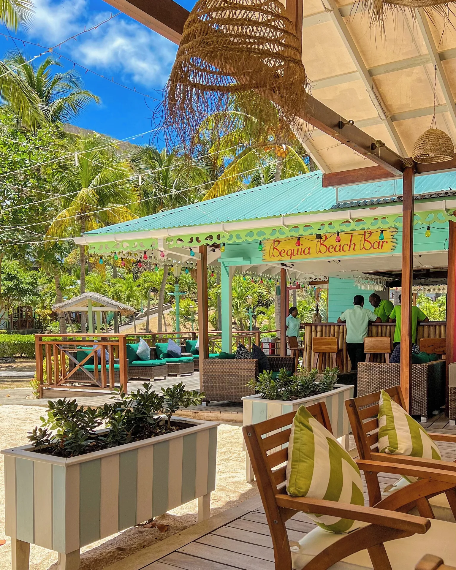 Bequia Beach Hotel with deck seating and palms at Bequia Beach Hotel.