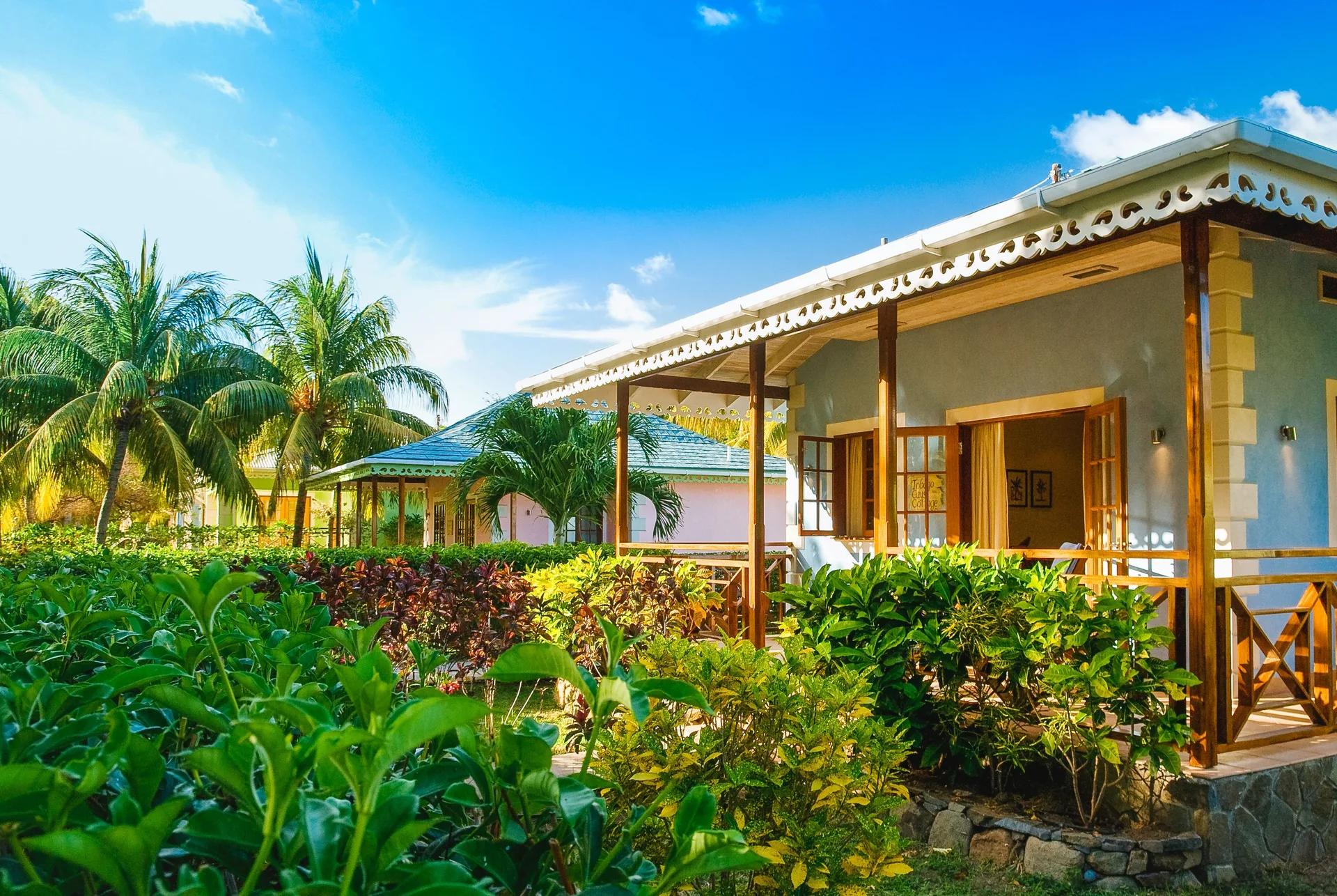 One Bedroom Cottage exterior with veranda and tropical gardens at Bequia Beach Hotel.