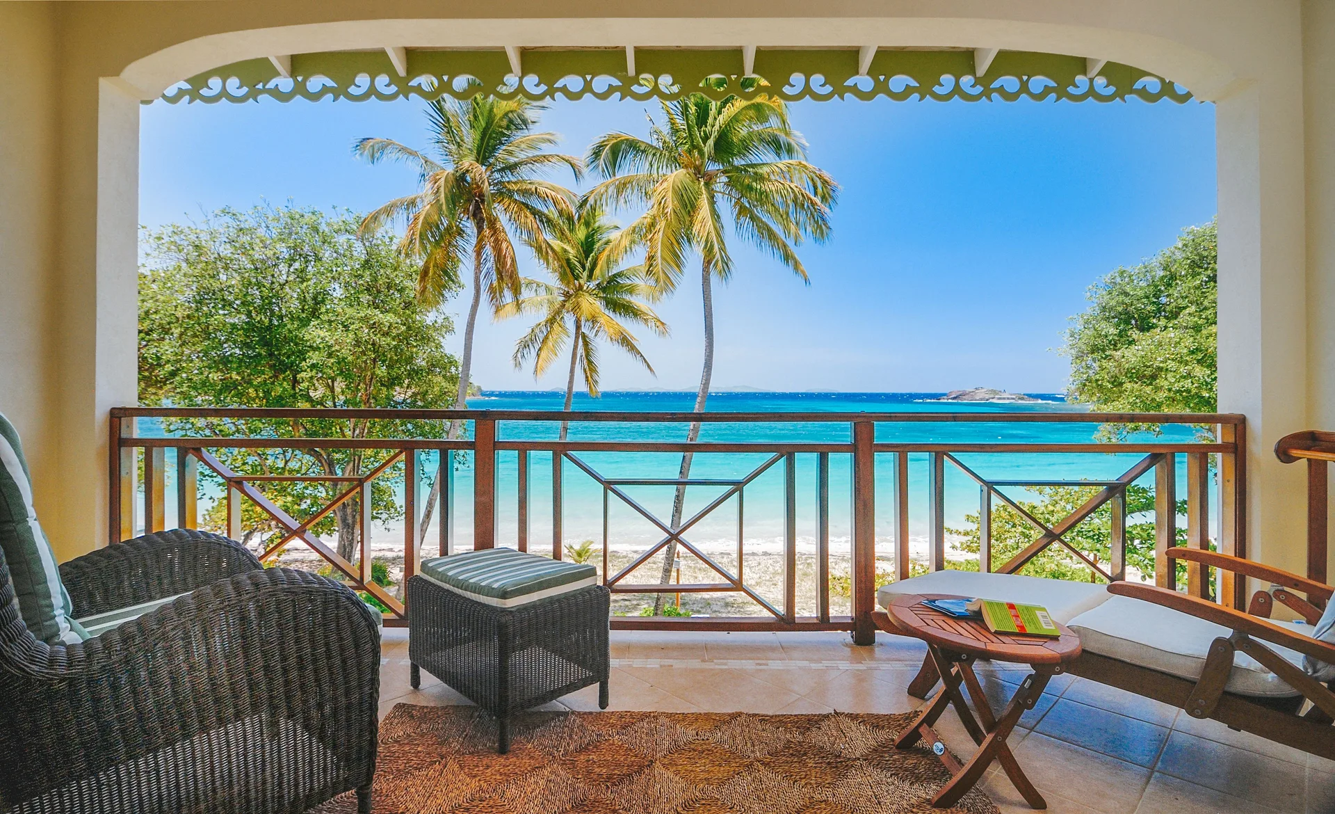 Covered beachfront balcony with seating and ocean view at Bequia Beach Hotel.